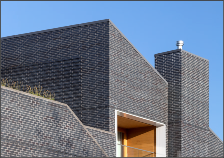 Sloping parapet forms and projecting bands provide dramatic brick detailing.